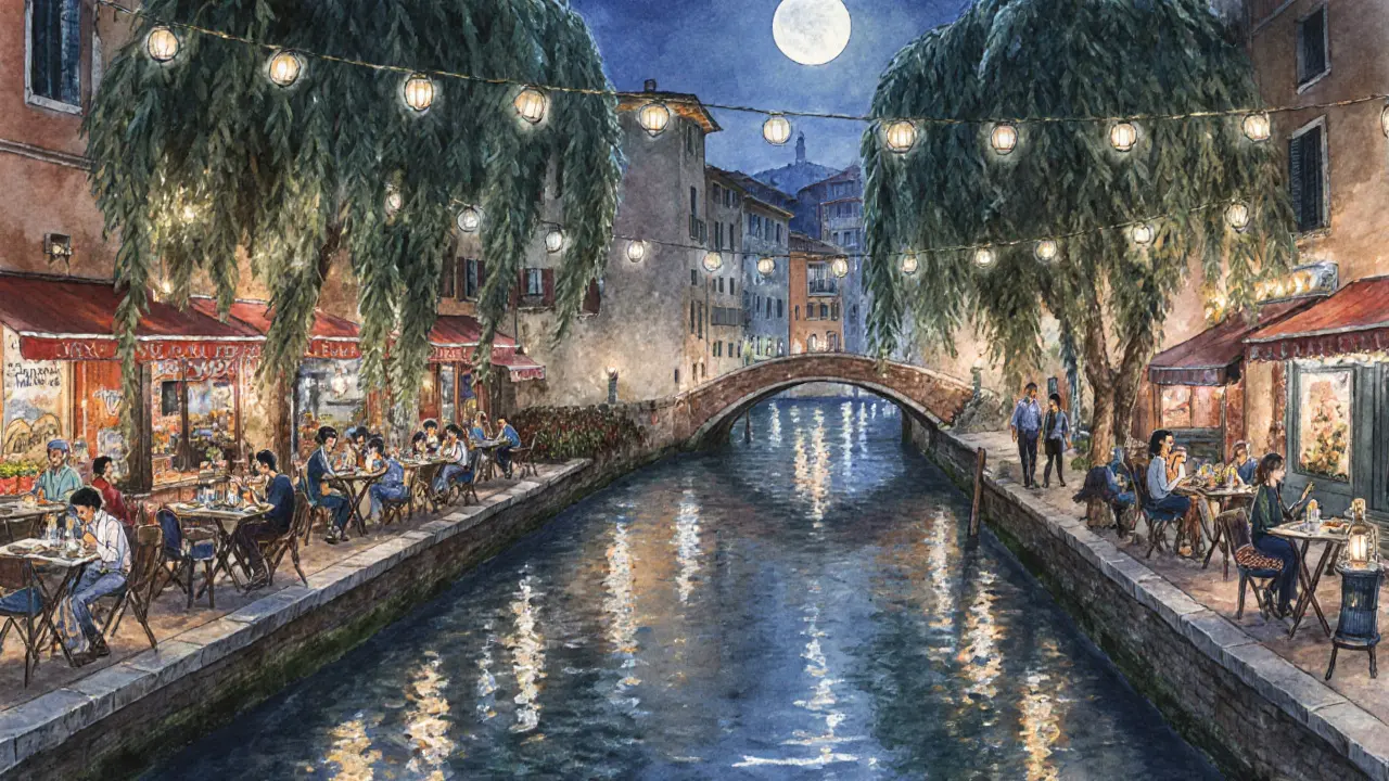 Evening scene along Milan&#039;s Navigli canal with outdoor tables, fairy lights, and people enjoying drinks by the water.