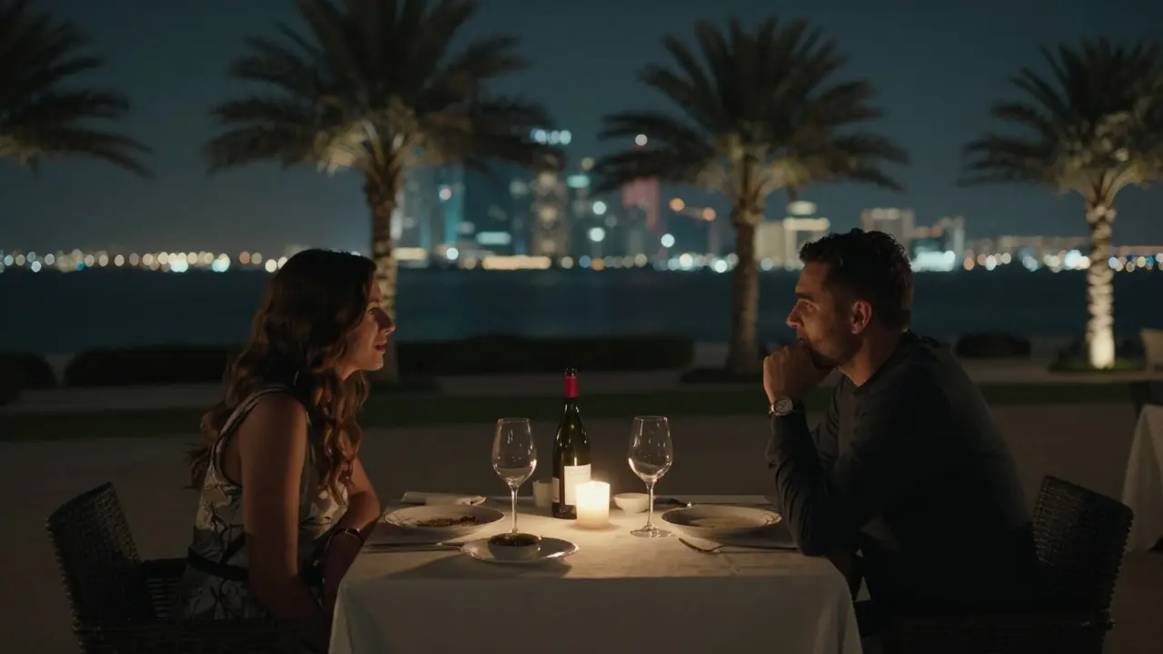 Two people dining quietly at a candlelit terrace overlooking the Corniche at night.